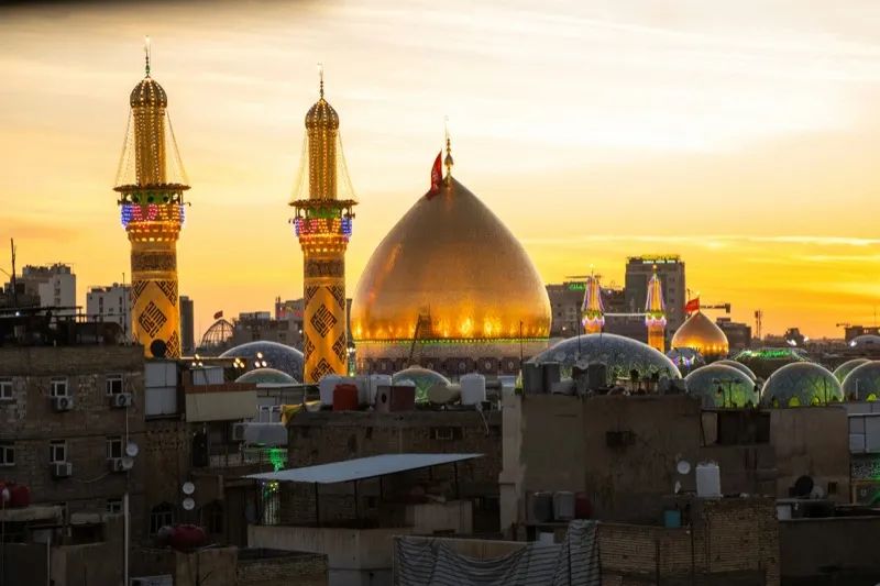 The golden shrine of Imam Husayn in Karbala glowing at sunset
