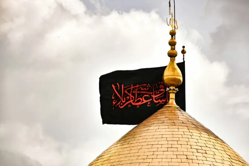 Black flag of mourning above a golden shrine dome during Muharram